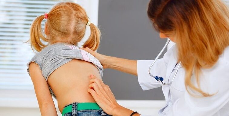 médico examinando as costas dun neno para detectar dor lumbar